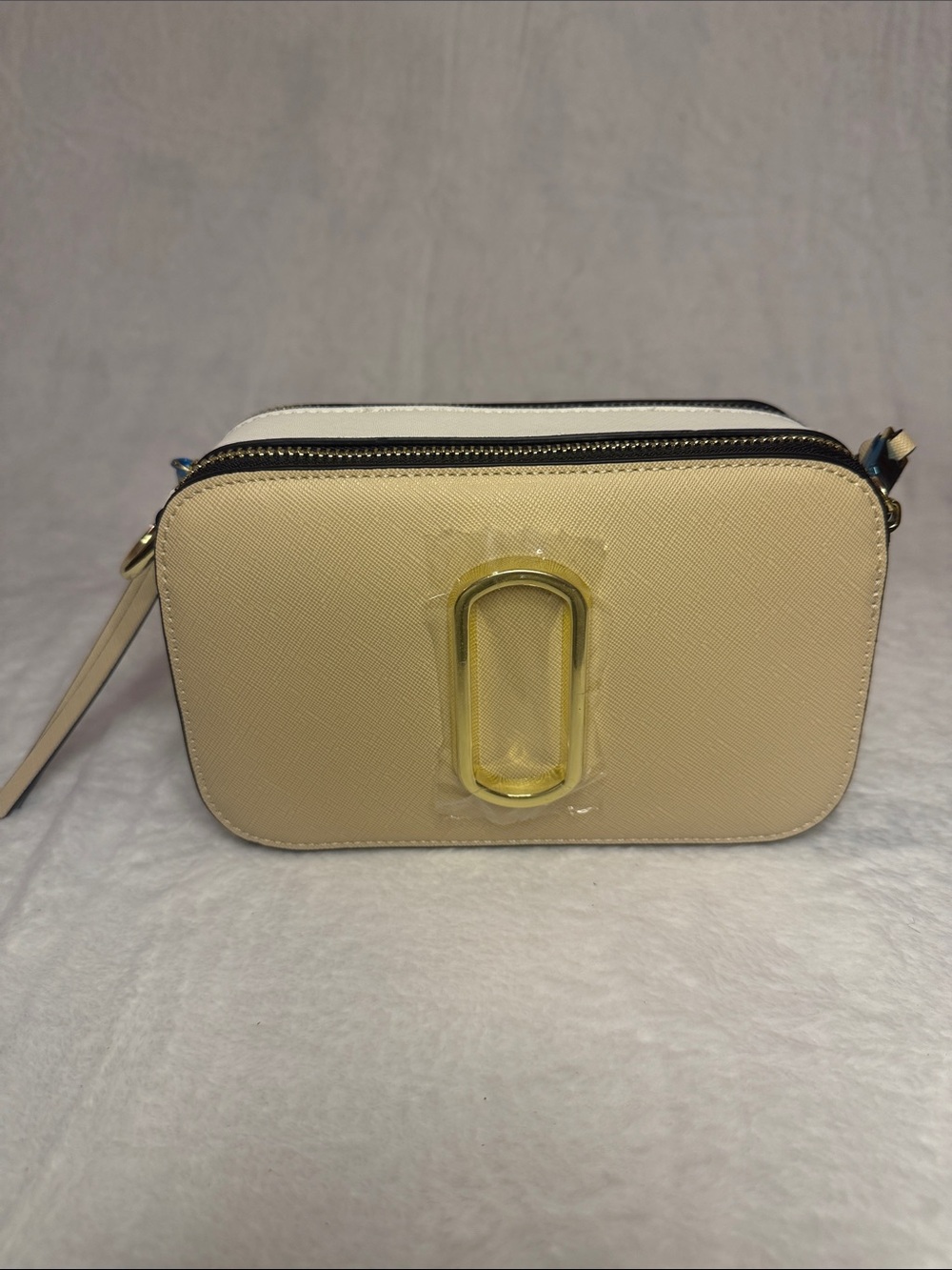 Neutral Cream Crossbody Bag with Gold Oval Accent and Removable Striped Strap